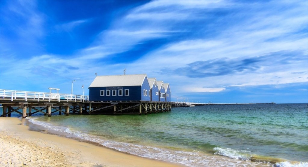 The iconic blue boatsheds at the entrance to Busselton Jetty with turquoise Geographe Bay waters